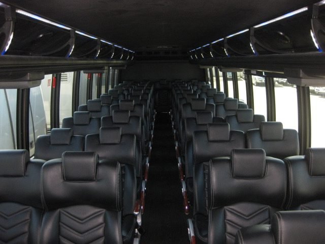 Executive Bus interior — forward-facing black leather coach seating, Ballantyne Limousine, Charlotte NC