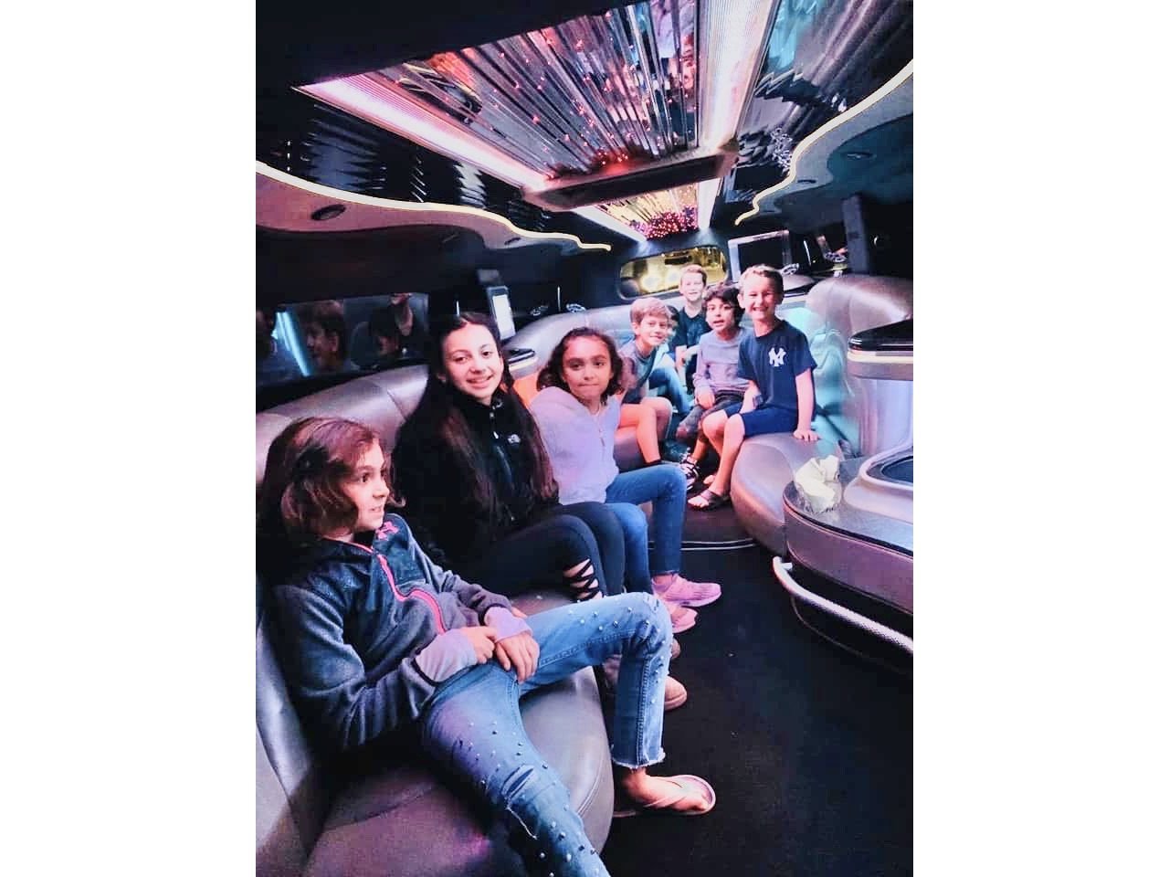 Passengers seated inside the white Hummer H2 stretch limousine — Ballantyne Limousine, Charlotte NC